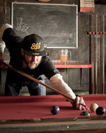 Load image into Gallery viewer, A man in a Uinta 801 hat shoots pool in a barroom
