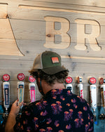 Load image into Gallery viewer, A person wearing a backwards hat and jellyfish shirt pours beer from a draft system
